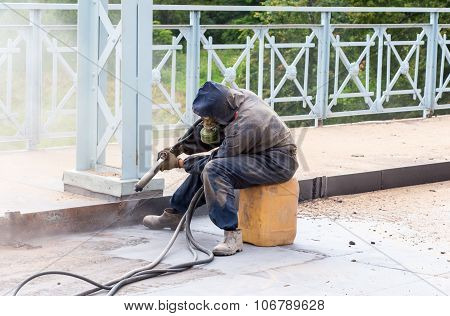 Worker In Protective Clothes Cleans The Metal Structures Sandblasting Tool