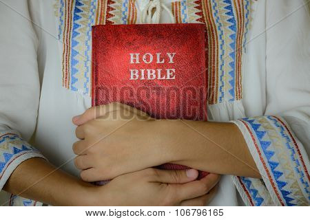 Hand Embracing Red Holy Bible
