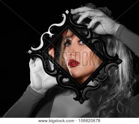 Pretty Young Woman Holding A Frame In Front Of Her Face