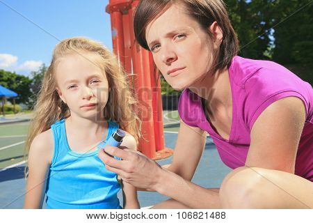 mother using inhaler with her asthmatic daughter