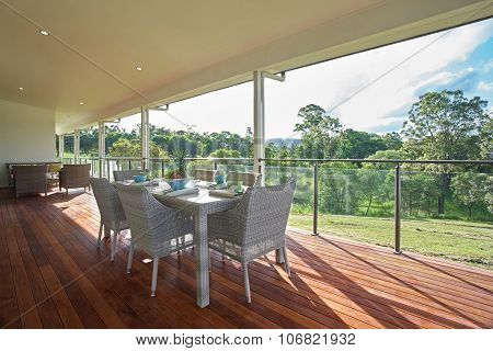 Dining Room Setting On The Patio Of Modern Spacious Farm House Deck.