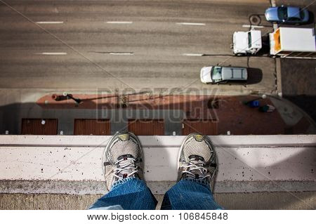 man standing on edge of tall building