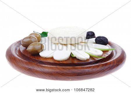dairy products : feta white cheese sliced on cut board with olives and basil leaves isolated over white background