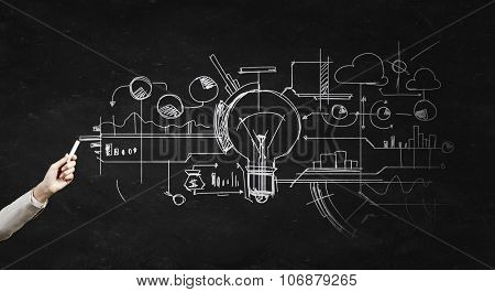 Human hand darwing light bulb as idea concept with chalk