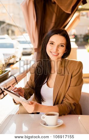 Young Woman With Digitale Tablet And Cup Of Coffee In Cafe