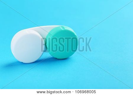 Contact Lenses In Container With Solution On Blue Background