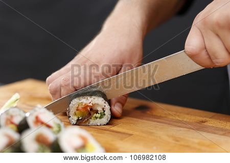 Master sushi knife slicing sushi rolls