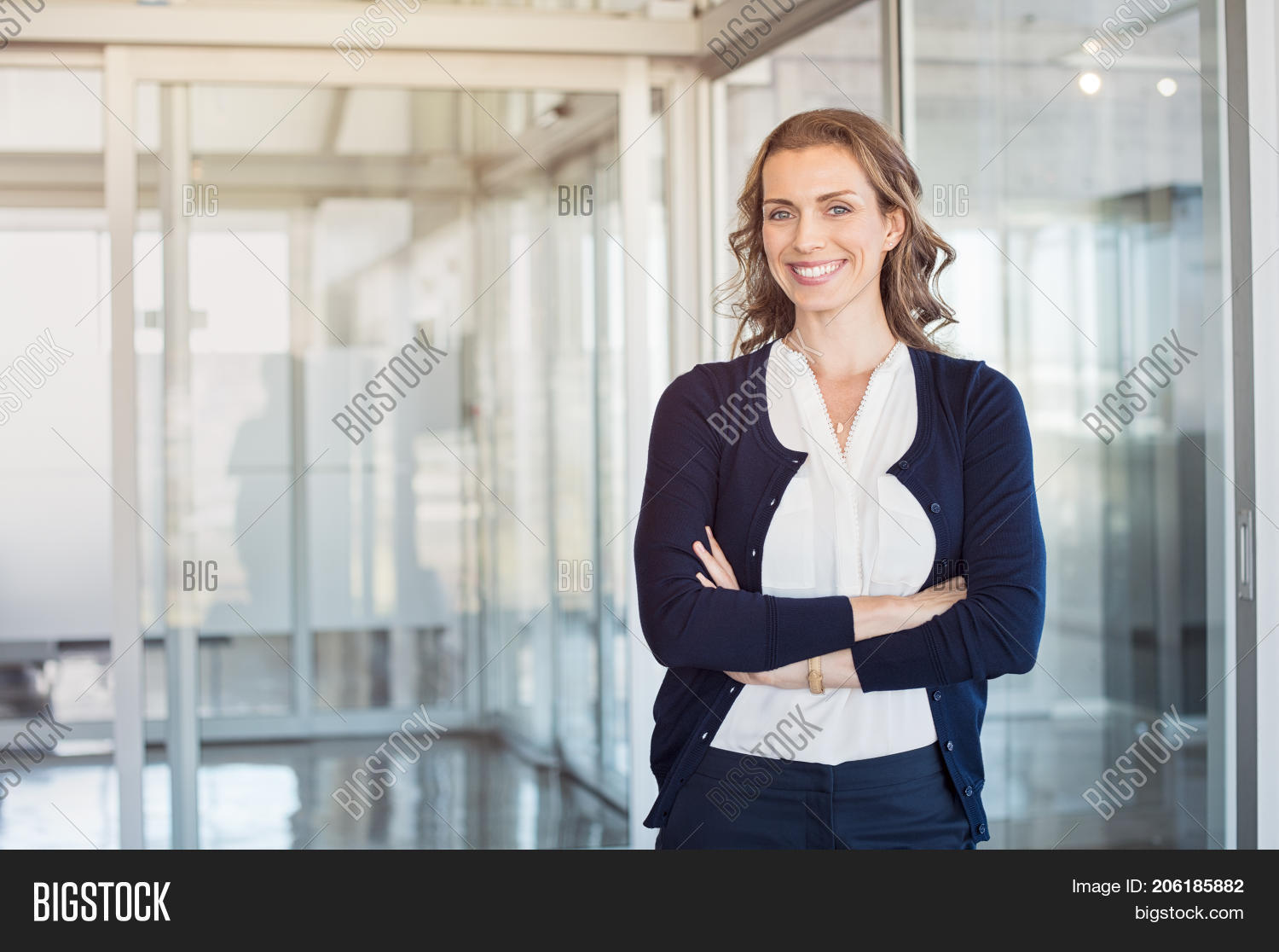 Smiling elegant confident middle aged woman standing in office