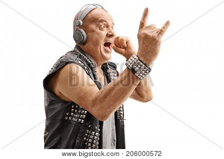 Elderly punker listening to music on headphones and making a rock hand gesture isolated on white background