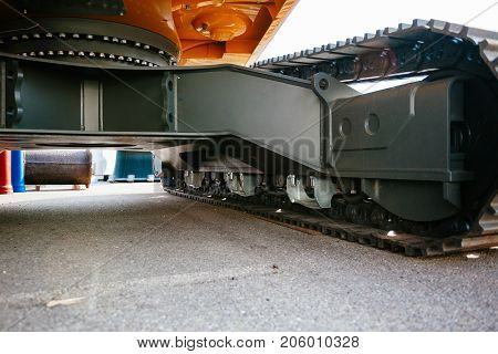 Under the brand new excavator - detail of the swing drive and slewing ring of modern powerful excavator on a construction site