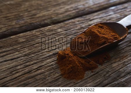 Rasam powder in scoop on a wooden table