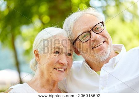 technology, retirement and old people concept - happy senior couple taking selfie and hugging at summer park