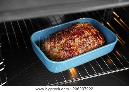 Baking dish with delicious turkey meatloaf in oven