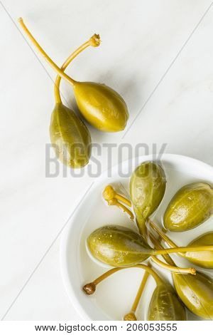 Pickled caper berries on kitchen table.