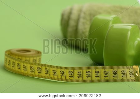 Dumbbells In Green Color, Twisted Measure Tape And Towel