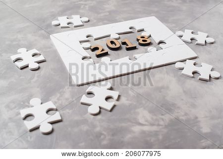 New Year Concept 2018. Jigsaw Puzzle On Grey Concrete Background.
