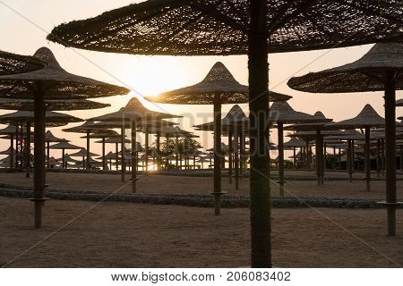 The beach with umbrellas and sun beds which are empty.