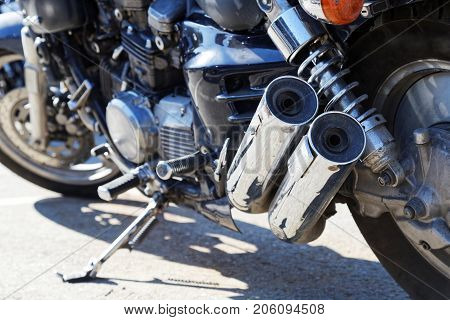 Closeup two exhaust pipes and rear suspension of motorcicle. Shallow focus.