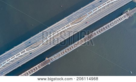 Aerial top view of automobile and railroad Darnitsky bridge across Dnieper river from above, Kiev (Kyiv) city skyline, Ukraine