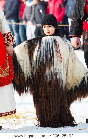 Razlog, Bulgaria - January 14, 2017: Child in traditional carnival kuker costumes at Kukeri festival Starchevata