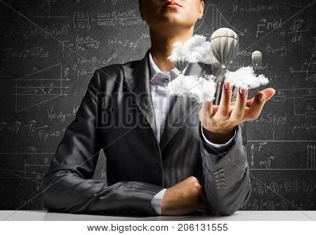 Closeup of business woman in suit presenting flying aerostate among clouds in her palm with business sketches on background. 3D rendering.