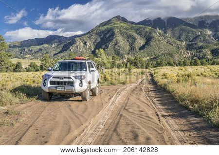 Great Sand Dunes National Park and Preserve - September 15, 2017: Toyota 4runner SUV (2016 Trail edition) with recovery sand ladders on roof driving on a sandy Medano Pass Road in late summer.