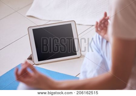 Woman With Digital Tablet Using Meditation App In Bedroom