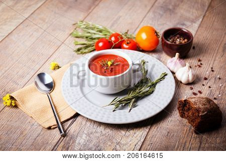 Red ukrainian borsch with two garlic, parsley and other different vegetables in a plate on a wooden table. Close-up of dish. Copy space. Food concept.