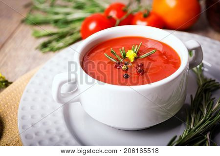 Red ukrainian borsch with sour, garlic, parsley, spices and a lot of dill and parsley on a wooden background. Copy space. Close-up of appetitzing dish. Food concept.