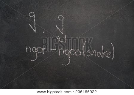 Thai letter written with white chalk on blackboard