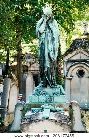 Statue of a weeping young woman at the Pere Lachaise cemetery in Paris