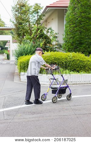 TOKYO JAPAN - SEPTEMBER 16 : unidentified asian old leprosy man walking with wheel waker for exercising in Tama Zensho Hospital on September 16 2017 in Tokyo Japan.