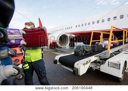 Ground Member Stacking Bags On Trailer At Runway