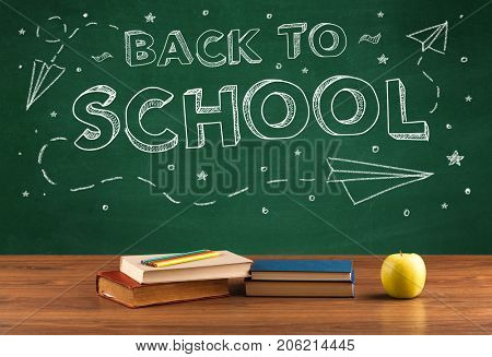 Back to school concepty with writing on blackboard and desk, apple, books, items