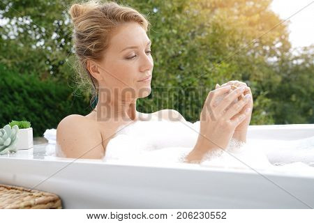 Beautiful woman in bath and using nailbrush