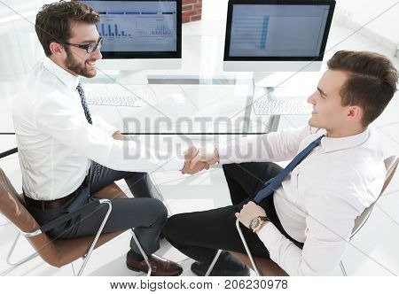 handshake financial partners sitting at Desk