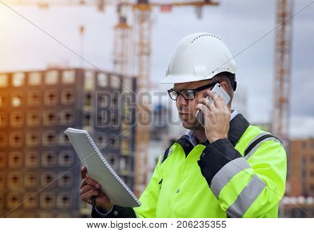 Construction engineer wearing safety vest with buildning  in the background