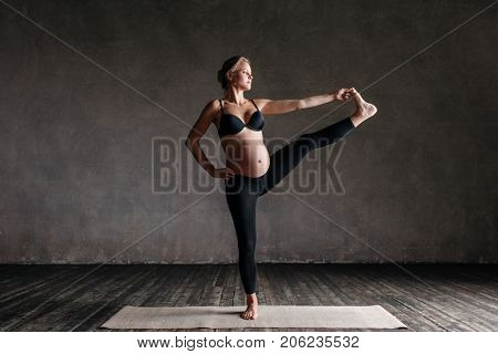 Young beautiful  pregnant yoga posing in studio
