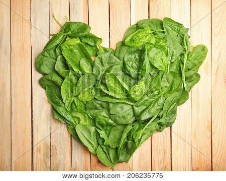 Fresh spinach leaves on wooden background
