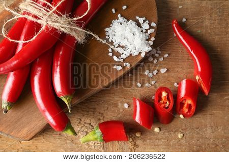 Red chili peppers and sea salt on wooden board