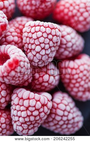 frozen raspberries on dark background - fruits and vegetables