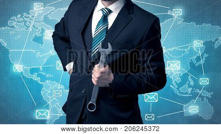 Businessman holding tool with global map graphic on the background