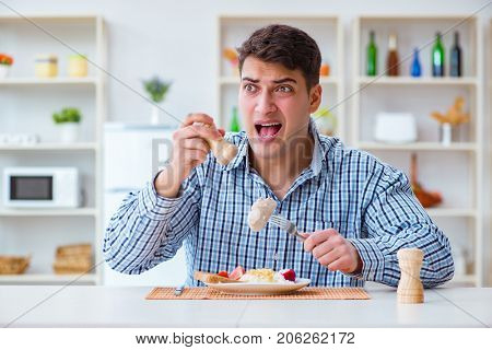 Man eating tasteless food at home for lunch