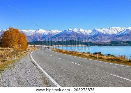Scenic Road along Lake Tekapo  at beautiful  sunny morning . Lake Tekapo and mountains with snow in autumn,  Canterbury, South Island, New Zealand.
