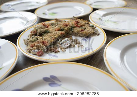 baked anchovy pie au gratin between a series of white dishes