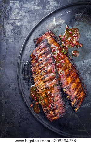 Barbecue Pork Spare Ribs with fruit relish as top view on an old rustic board 