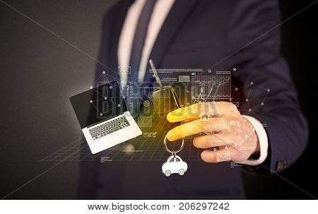 Businessman in suit holding keys with statistics, graphs and icons around