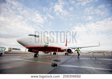 Commercial Airplane On Wet Runway Against Cloudy Sky