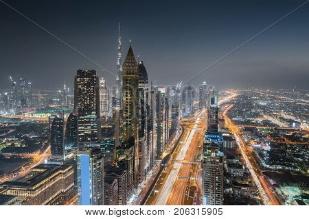 DUBAI, UAE - JAN 8, 2017: Burj Khalifa, Rose Rayhaan by Rotana, Ahmed Abdul Rahim Al Attar Tower at night, Sheikh Zayed highway