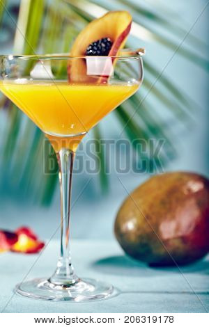Summer  Cocktail -  Pornstar Martini. Drink with Passion fruit, Vodka, Liquor, Vanilla Syrup, Champagne and Lime Juice. Tropical Leaf on Background